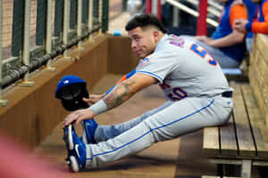 Baseball Player Relaxingin Dugout Wallpaper