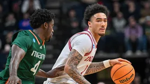 Basketball Player Dribbling Past Opponent Wallpaper