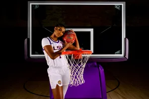 Basketball Player Posingwith Ballat Hoop Wallpaper