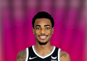 Basketball Player Smiling Against Pink Background Wallpaper