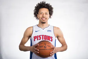 Basketball Playerin Pistons Jersey Holding Ball Wallpaper