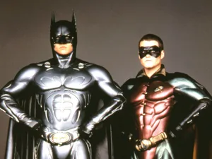 Batman And Robin Soaring Over Gotham City Wallpaper