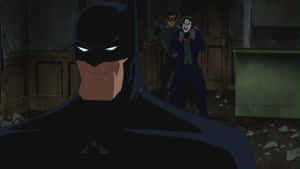 Batman Confronts The Red Hood In A Thrilling Showdown Wallpaper