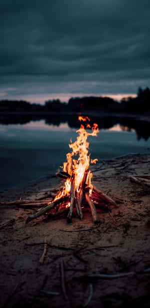 Beach Bonfire Under Twilight Sky Wallpaper