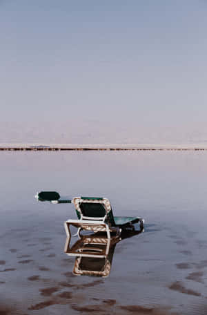 Beach Lounge Chair In The Still Water Wallpaper