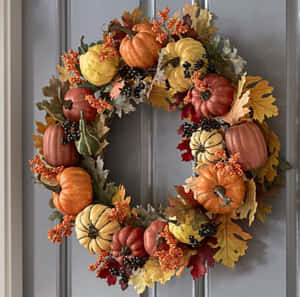 Beautiful Fall Wreath Adorning A Rustic Door Wallpaper