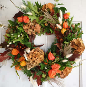 Beautiful Fall Wreath On Rustic Wooden Door Wallpaper