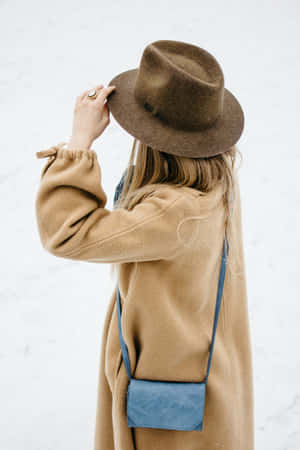 Beige Coat Woman Holding Hat Snow Background Wallpaper