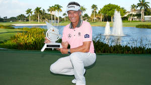 Bernhard Langer Crouching And Holding Trophy Wallpaper