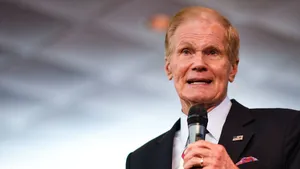 Bill Nelson With Microphone And Gray Backdrop Wallpaper