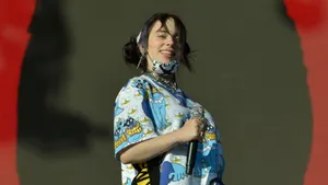 Billie Eilish Confidently Turns On Her Laptop, Ready To Create Her Unique Style Of Music. Wallpaper