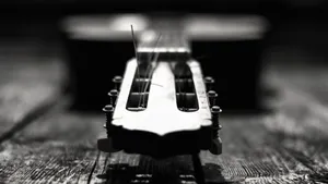 Black And White Guitar Resting On Wall Wallpaper