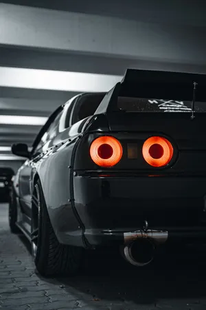 Black Sports Car Rear View Nighttime Wallpaper