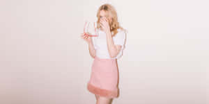 Blonde Woman Pink Skirt Holding Glasses Wallpaper