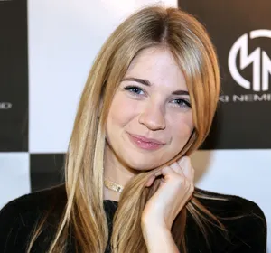 Blonde Woman Smilingat Event Wallpaper