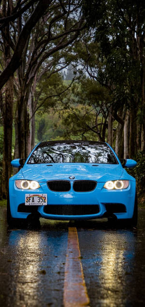 Blue Bmw In Tree-covered Pathway Wallpaper