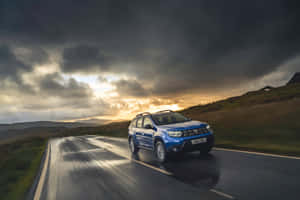 Blue Dacia Duster Driving Stormy Weather Wallpaper