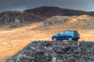 Blue Dacia Duster Mountainous Terrain Wallpaper