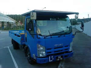 Blue Isuzu Elf Truck Parked Wallpaper