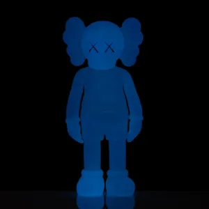 Blue Kaws Figure Standing Against Black Background Wallpaper