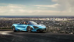 Blue Mclaren Spyder Near City Wallpaper