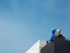 Blueand Grey Kaws Sculptureson Building Wallpaper