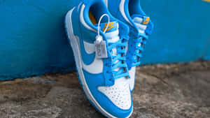 Blueand White Sneakers Against Blue Wall Wallpaper