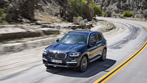 Bmw X3 Gliding On A Scenic Highway Wallpaper