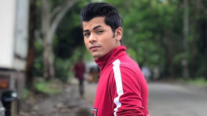 Bollywood Sensation Siddharth Nigam Striking A Pose In A Red Track Jacket Wallpaper