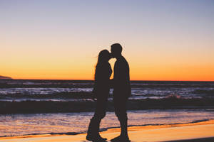 Boyfriend And Girlfriend Kiss At The Beach Wallpaper