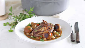 Braised Chicken Coq Au Vin On A White Plate Wallpaper