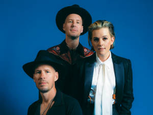 Brandi Carlile Alongside Hanseroth Twins Against A Natural Backdrop. Wallpaper