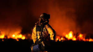 Brave Firefighter Extinguishing Flames Wallpaper