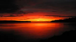 Breathtaking Orange Sunset Over The Ocean Wallpaper