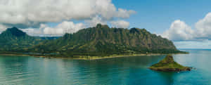 Breathtaking View Of A Hawaiian Island Surrounded By Crystal-clear Ocean Water Wallpaper