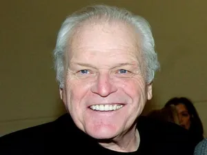 Brian Dennehy Smiling On Brown Background Wallpaper