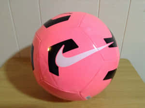 Bright Pink Soccer Ball On Vibrant Green Grass Wallpaper