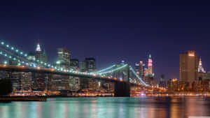 Brooklyn Bridge At Night With The City Lights Wallpaper