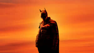 Bruce Wayne Striking A Confident Pose In Front Of The Gotham City Skyline. Wallpaper