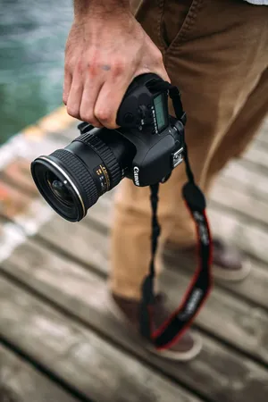 Cameraman_ Holding_ D S L R_ Camera Wallpaper