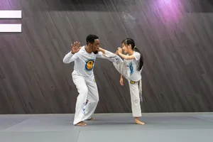 Capoeira Coach Teaching A Student Wallpaper