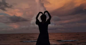 Caption: A Romantic Heart Silhouette Against A Gradient Sunset Wallpaper
