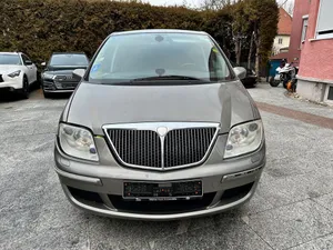 Caption: A Silver Lancia Phedra Parked Outdoors Wallpaper