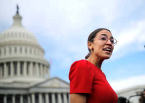 Caption: Alexandria Ocasio-cortez In A Vibrant Red Dress Wallpaper