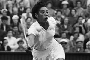 Caption: Althea Gibson Smashing A Tennis Match Wallpaper