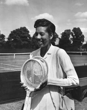 Caption: Althea Gibson Triumphantly Holding A Tennis Racket Wallpaper