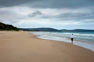 Caption: Beach Walk At Sunset Wallpaper