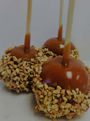 Caption: Caramel Apples On A Wooden Table Wallpaper