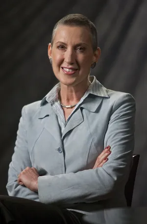 Caption: Carly Fiorina Displaying Leadership With Crossed Arms Wallpaper
