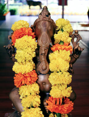 Caption: Celebrating Ganesh Chaturthi - Vibrant Orange And Yellow Flowers Wallpaper